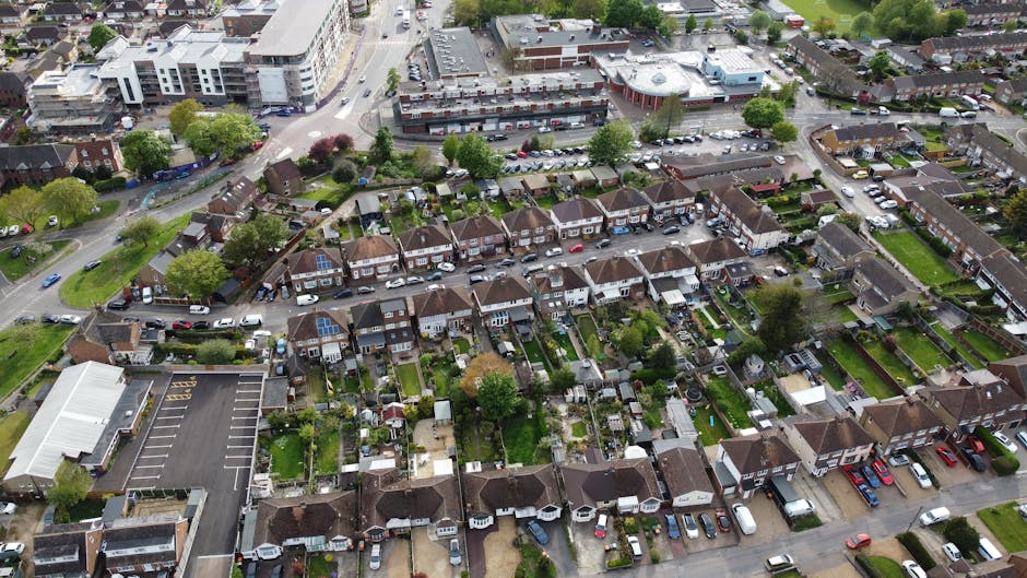 An aerial view of a suburban residential area in Upper Norwood, Croydon, showing a variety of houses with back gardens, some of which feature lawn areas, flower beds, and trees. The image includes a m